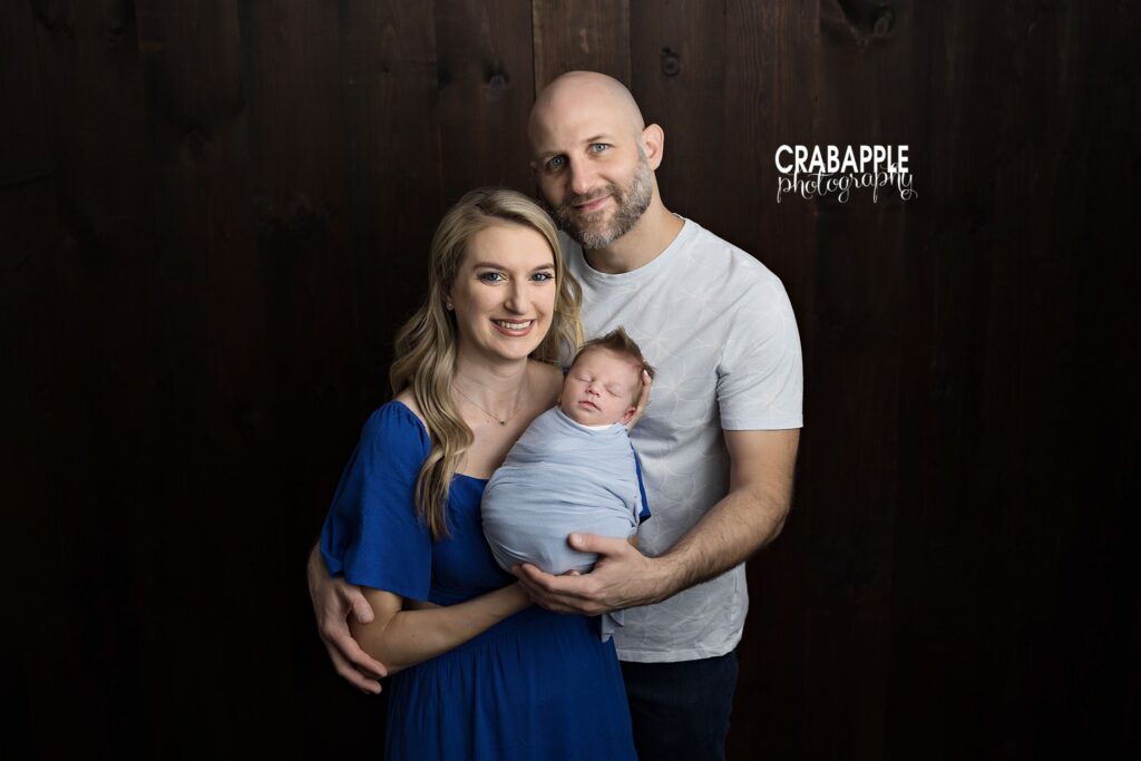 Parents holding their newborn baby boy for a classic family portrait
