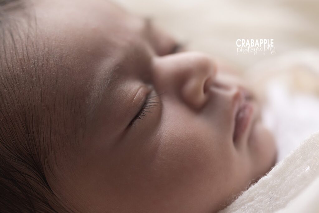 Close-up detail of a newborn girl's face and delicate eyelashes	